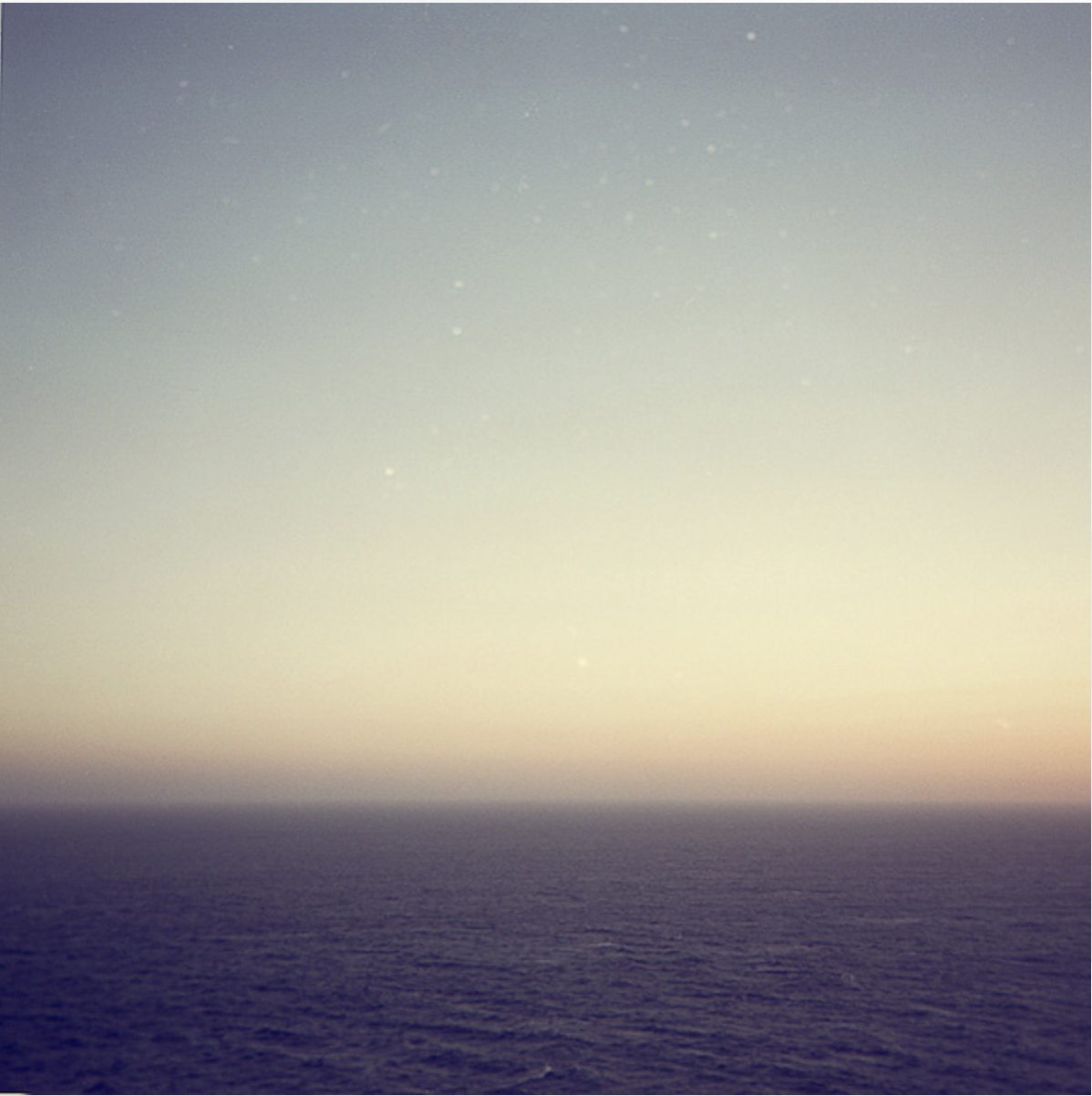 Deep blue sea at dusk beneath a fading sky